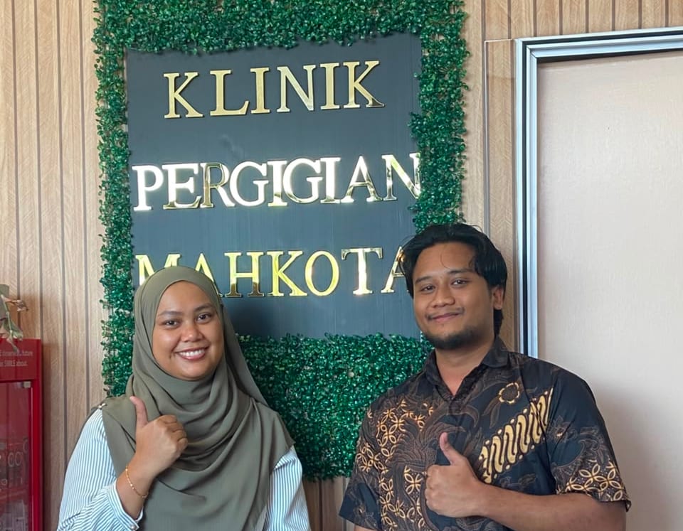 Imran with Dr Hedaya at the Klinik Pergigian Mahkota sign in Kota Warisan